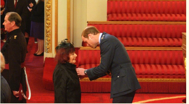 Alanna Knight
              receiving her MBE from Prince William